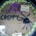 picture of a Halloween cake with the decoration of a spider and the word creepy spelled as creppy