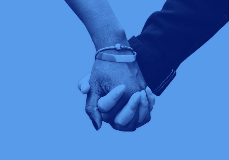 image of two hands holding each other on a blue blackground.