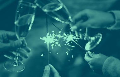 close-up of hands holding champagne glasses and sparklers, teal color.