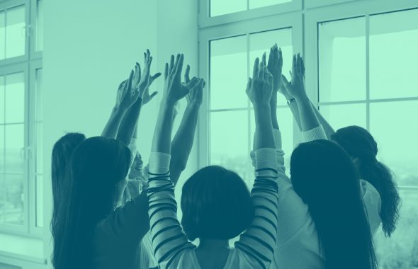 group of people with hands raised together, green filter