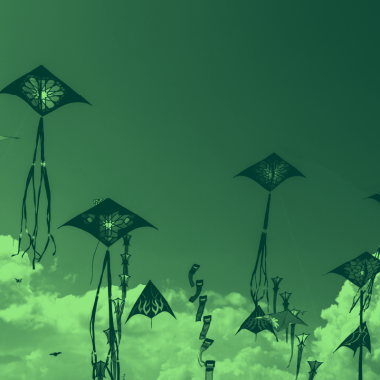 kites flying above clouds, green filter