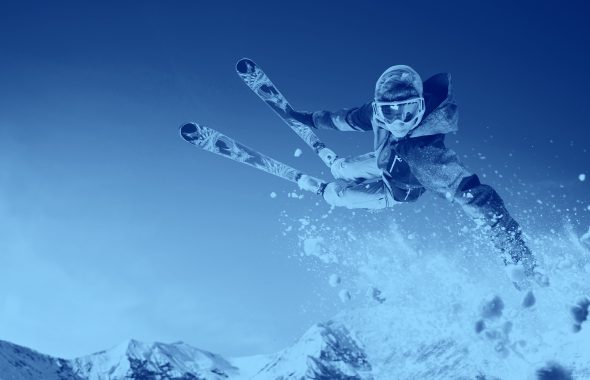 Skier jumping over snow, blue filter.
