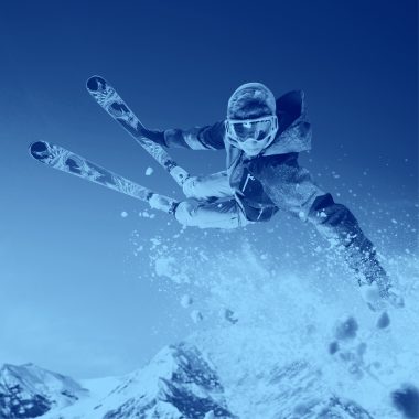 Skier jumping over snow, blue filter.