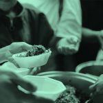 Close-up of serving food to a group, teal filter