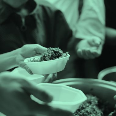 Close-up of serving food to a group, teal filter