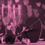 2 champagne glasses and a heart-shaped box of chocolates, pink filter