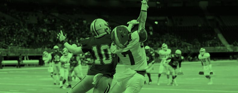 two football players trying to catch the football, green filter