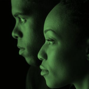 Side view of two young African American people on black background
