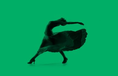 Latin dancer striking a pose, green background.