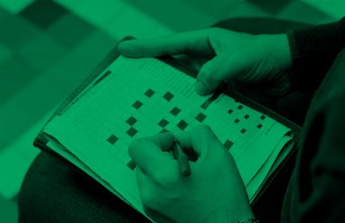 close-up of someone working on a crossword puzzle, green filter.