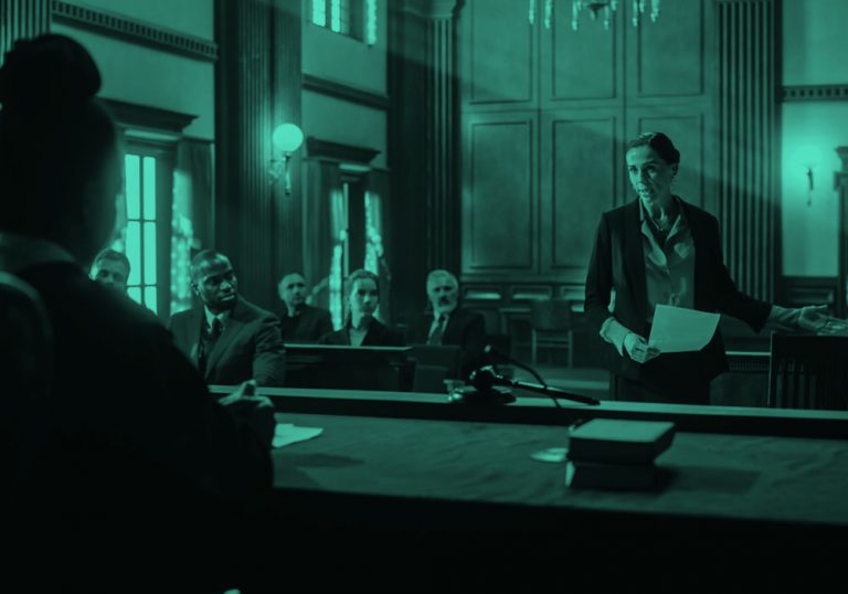 female lawyer speaking to judge in a courtroom, teal filter.
