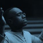 Male with his arms raised as if praising at church