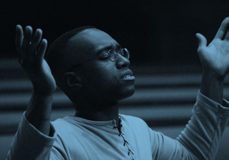 Male with his arms raised as if praising at church