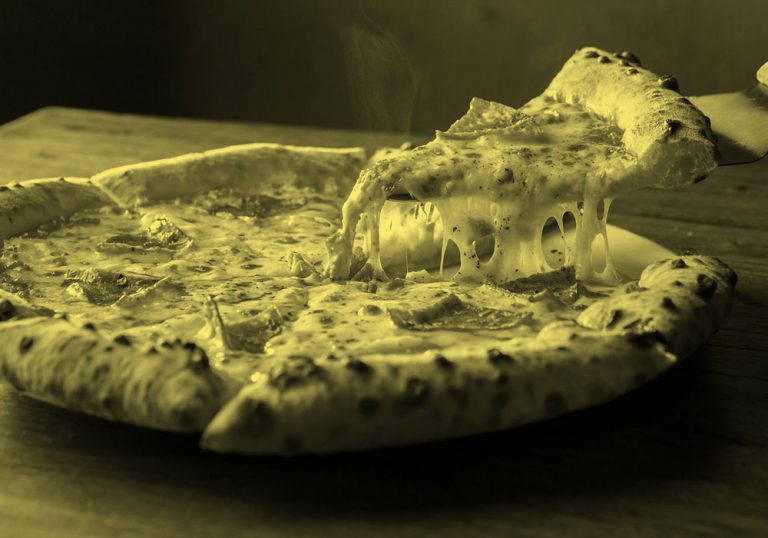 A whole pizza pie with one slice cut and ready to serve