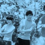 Photo of four young friends doing the "Gangnam Style" dance, blue filter.