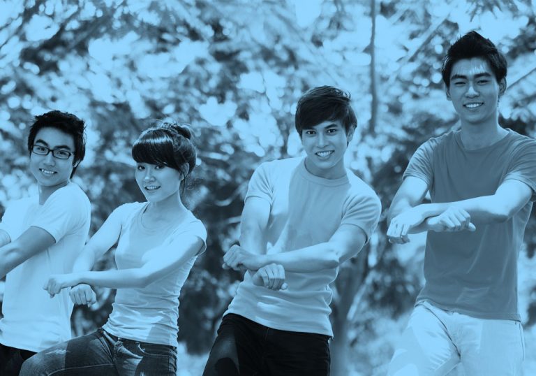 Photo of four young friends doing the "Gangnam Style" dance, blue filter.