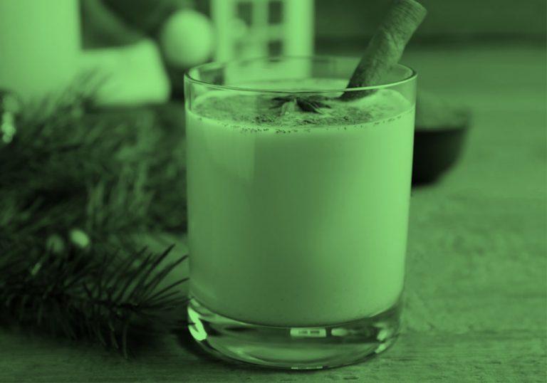 glass of eggnog with cinnamon stick