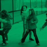 photo with a green tint of five boys and girls playing in a classroom