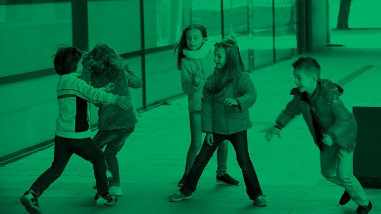 photo with a green tint of five boys and girls playing in a classroom