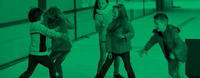 photo with a green tint of five boys and girls playing in a classroom