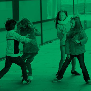 photo with a green tint of five boys and girls playing in a classroom