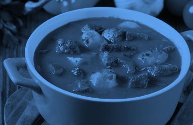 a pot of stew on a dining table, blue filter.