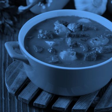 a pot of stew on a dining table, blue filter.