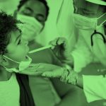 A doctor examining a child patient's mouth with parent sitting on the side, green filter.