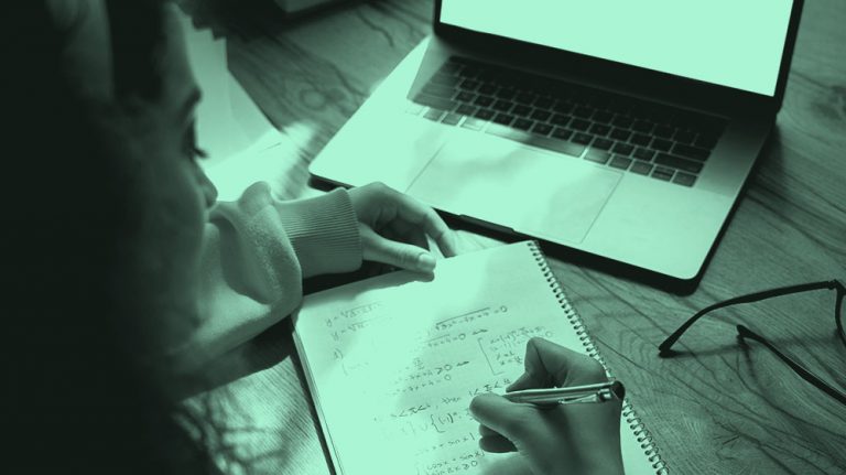 woman doing math calculations in a notebook, teal filter.