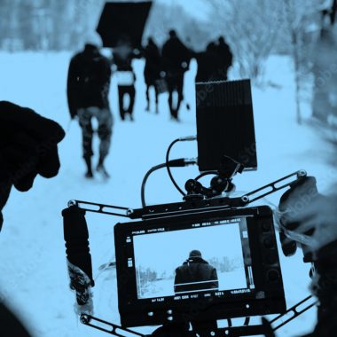 view of professional camera filming a group of people, in blue filter.