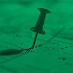 push pin marking a location on a map, green filter.