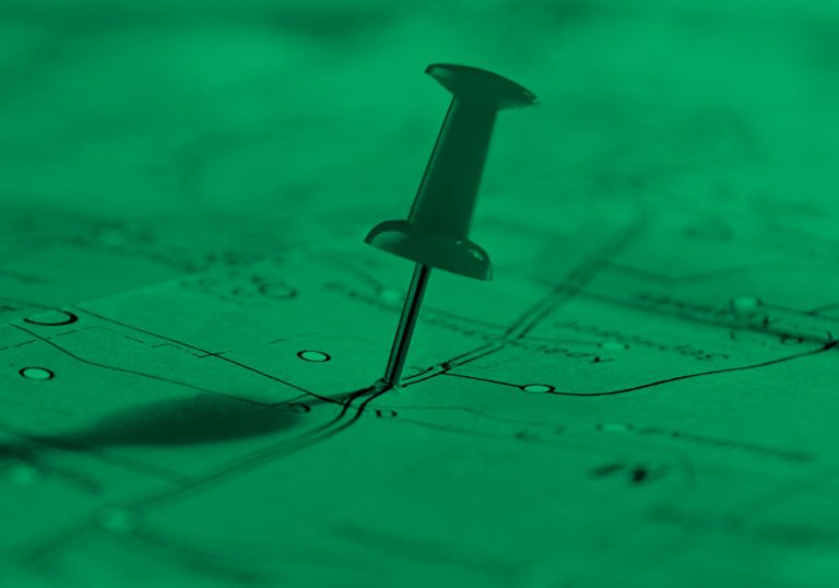 push pin marking a location on a map, green filter.