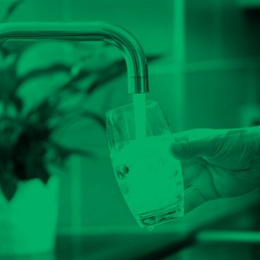 filtered image of someone filling up glass of water from faucet