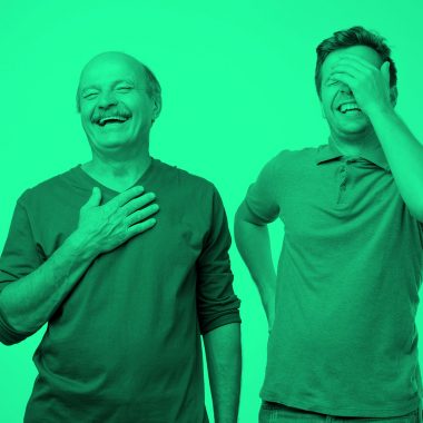 older and younger men laughing; green filter